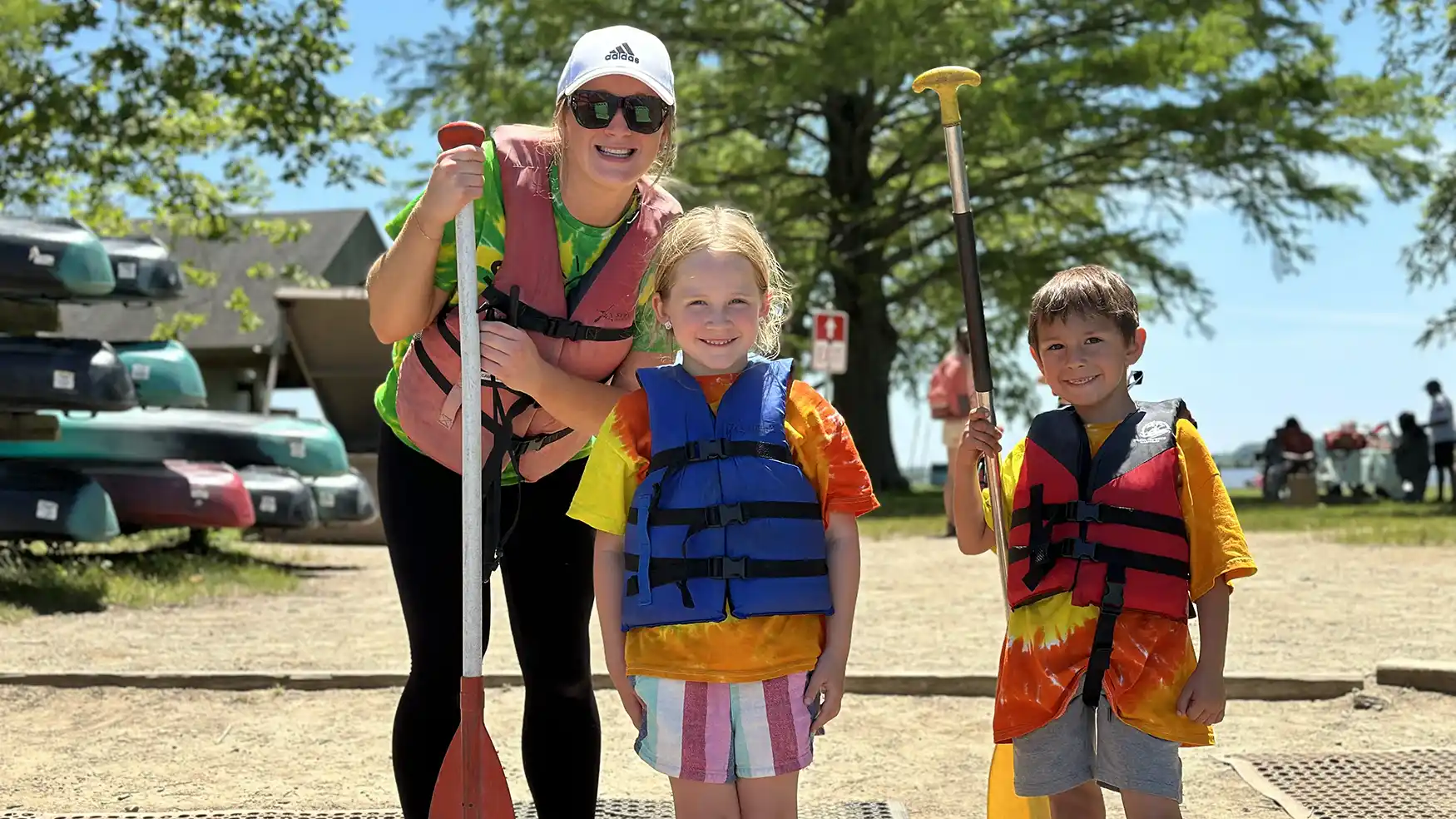 Female adult with two young children. All wearing life jackets.